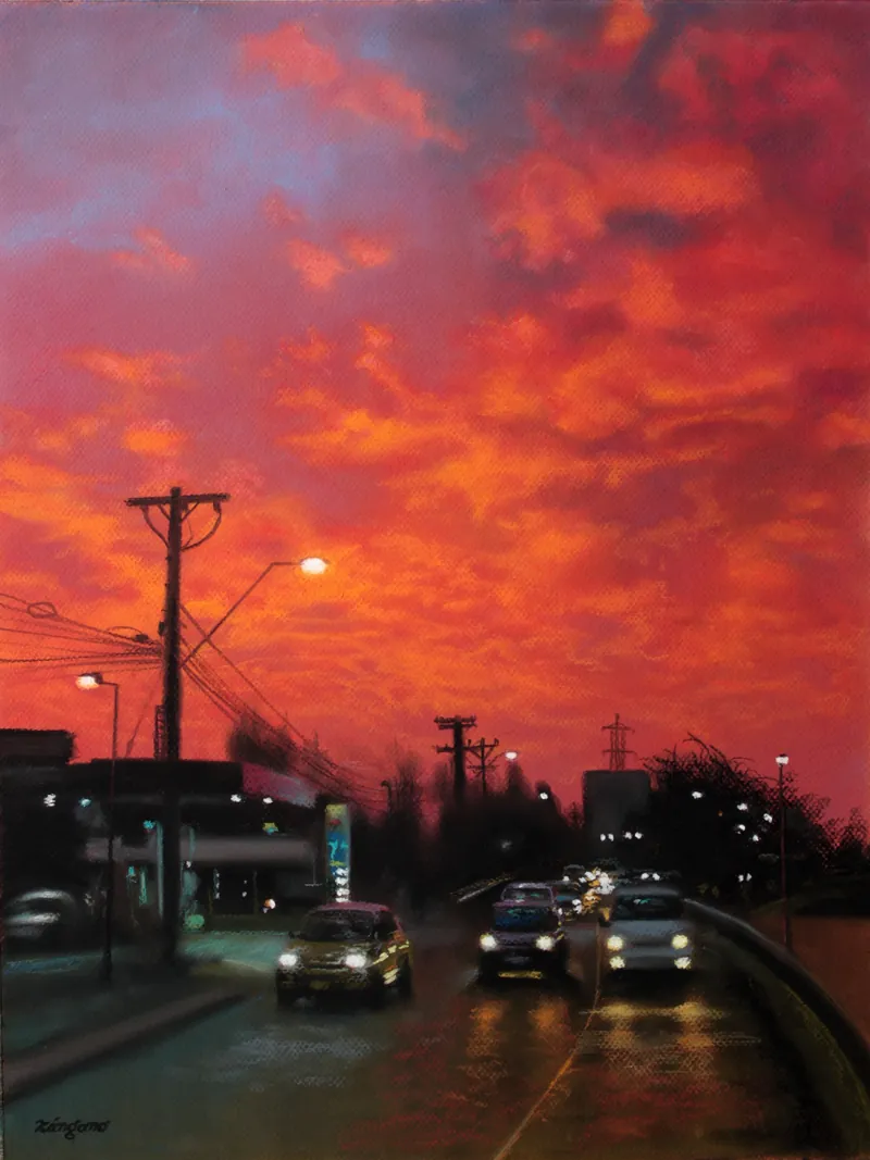 Calle al atardecer con autos encendidos y un cielo rojo intenso.