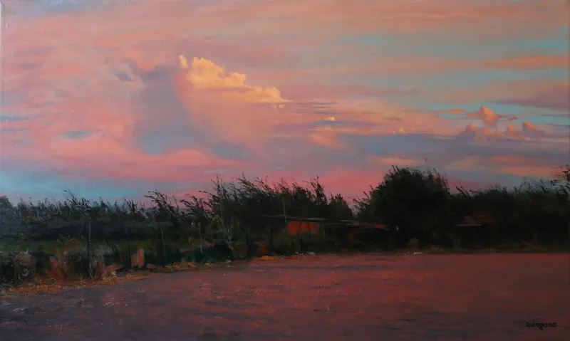 Potrero con árboles bajo un cielo rosado al atardecer.